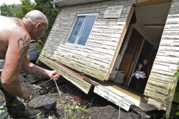 West Virginia floods Jason Bergnoli, left, uses a rope to retrieve documents