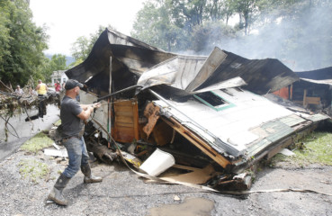 West Virginia floods Lee Bland, of White Sulphur Springs, looks for belongings in the burned out home