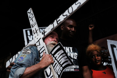 Vote 4 Jesus A man walks with a cross