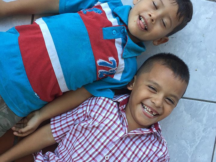 Two boys from Honduras play on a floor in Tapachula park.