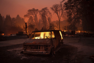 California Wildfires Flames burn inside a van