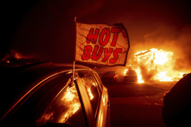 California Wildfires Flames consume a car dealership