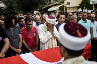 Mourners gather at the funeral of a victim of the Istanbul attack A man gestures as people gather in front of the coffin for the funeral of Turkish teacher Huseyin Tunc two days after the triple suicide bombing and gun attack occurred at Istanbul's Ataturk airport