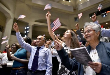 New US citizens wave flags after taking the Oath of Allegiance to the United States during a naturalization ceremony on World Refugee Day New US citizens wave flags after taking the Oath of Allegiance to the United States during a naturalization ceremony on World Refugee Day