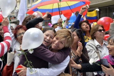 Colombians in Bogota celebrate the ceasefire Colombians celebrate in downtown Bogota as they watch on a giant screen the signing of the ceasefire between the Government and the FARC guerrillas