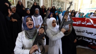 Iraqi Shiite women hold their weapons as they gather to show their willingness to join Iraqi security forces