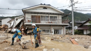 Rescue workers look for survivors at the site of a landslide after heavy rains hit the city of Hiroshima