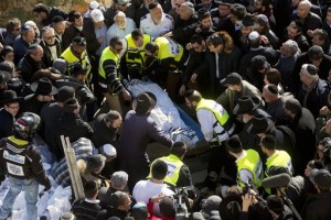 Israeli and French friends, and relatives, carry the body of Philippe Braham during the funeral of four French Jewish victims of an attack last week on a kosher grocery store in Paris, in a cemetery in Jerusalem, Tuesday, Jan. 13, 2015. Thousands of mourners joined Israeli leaders and the families of the four Jewish victims of a Paris terror attack on a kosher supermarket for an emotional funeral procession on Tuesday, reflecting the deep sense of connection and concern in Israel over the safety of fellow Jews in Europe. (AP Photo/Sebastian Scheiner)