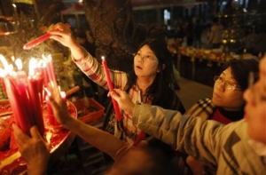 Devotees light candles on the eve of the Chinese New Year at the Lungshan Temple in Taipei, Taiwan, Wednesday, Feb. 18, 2015. According to the Lunar calendar, Chinese will celebrate the Lunar New Year on Feb. 19 this year which marks the Year of the Sheep. (AP Photo/Wally Santana)