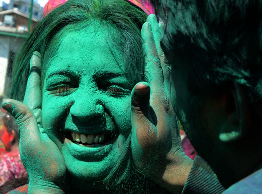 Members of the Nepalese ethnic Madhesi community daub each other's faces with colored powders during Holi festival celebrations in Kathmandu on March 6, 2015. The Holi festival of colors is a riotous celebration of the coming of spring and falls on the day of the full moon in March every year. AFP/ Prakash Mathema