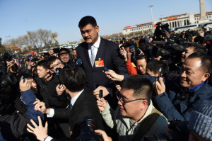 Former Chinese NBA star Yao Ming makes his way through a crowd of journalists to the steps of the Great Hall of the People as he arrives for the opening session of the Chinese People's Political Consultative Conference (CPPCC) in Beijing on March 3, 2015. Thousands of delegates from across China and the Chinese leadership will gather for its annual legislature meetings from March 3 in Beijing. AFP PHOTO / Greg BAKER