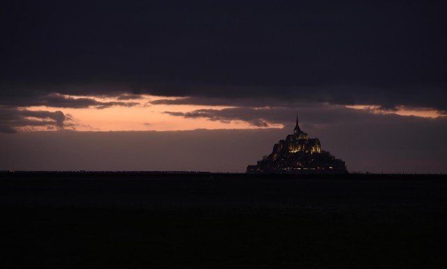 View of the Mont Saint-Michel and its Gothic Benedictine abbey on March 21, 2015 at sunset, as driven by the effects of the solar eclipse on March 20, this year's spring tide is considered the "tide of the century" with a coefficient of 119 out of a possible maximum of 120.  (AFP/ Eric Feferberg)