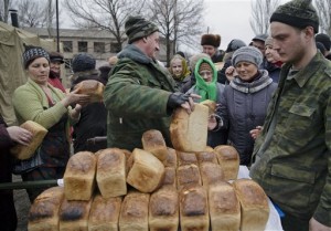 Bread baked by Russia-backed separatists is distributed, one per person, to residents in Chornukhyne, Ukraine, Monday, March 2, 2015. More than 6,000 people have died in eastern Ukraine since the start of the conflict almost a year ago that has led to a "merciless devastation of civilian lives and infrastructure," the U.N. human rights office said Monday. (AP Photo/Vadim Ghirda)