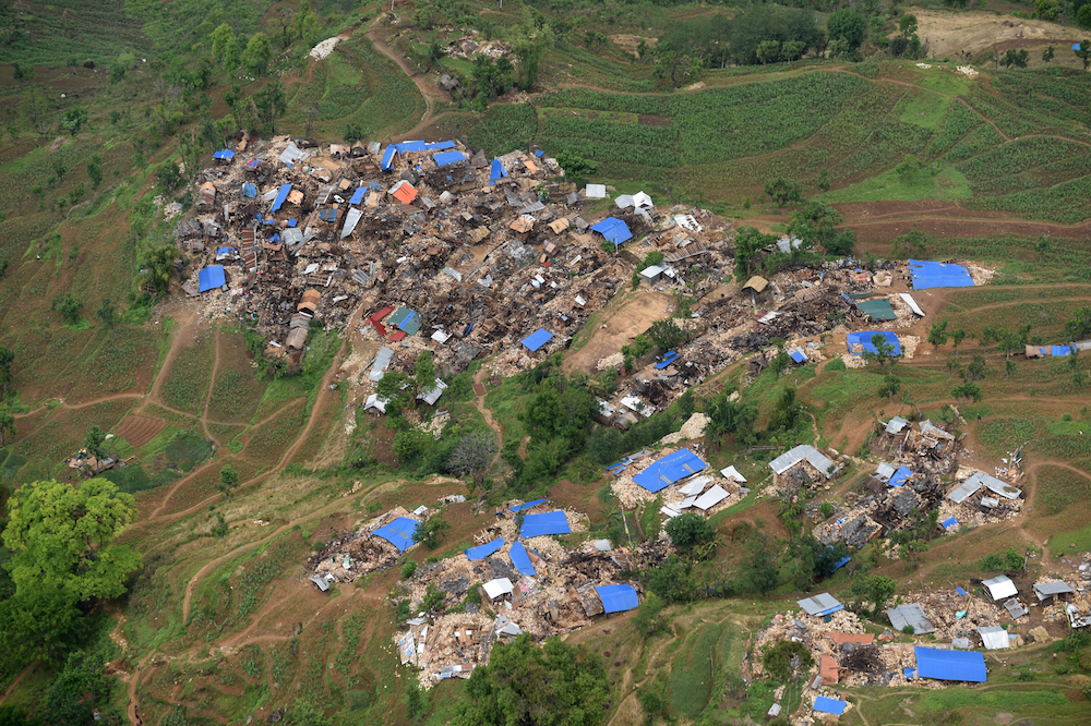 TOPSHOTS Damaged houses are pictured from an Indian Army helicopter at Barpak village, in northern-central Gorkha district on April 29, 2015.   Hungry and desperate villagers rushed towards relief helicopters in remote areas of Nepal, begging to be airlifted to safety, four days after a monster earthquake killed more than 5,000 people.    AFP PHOTO / SAJJAD HUSSAIN