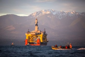 A boat crosses in front of an oil drilling rig as it arrives in Port Angeles, Wash. on April 17, 2015. Royal Dutch Shell hopes to use the rig for exploratory drilling during the summer open-water season in the Chukchi Sea off Alaska's northwest coast, if it can get the permits. (Daniella Beccaria/seattlepi.com via AP)