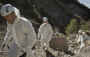 In this photo provided Friday, April 3, 2015 by the French Interior Ministry, French emergency rescue services work among debris of the Germanwings passenger jet at the crash site near Seyne-les-Alpes, France. The co-pilot of the doomed Germanwings flight repeatedly sped up the plane as he used the automatic pilot to descend the A320 into the Alps, the French air accident investigation agency said Friday. (AP Photo/Yves Malenfer, Ministere de l'Interieur)