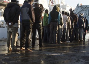 Rescued migrants line up after disembarking from the Italian Coast Guard ship 'Fiorillo' in the harbor of of Lampedusa, Southern Italy, Wednesday, April 22, 2015. Italy pressed the European Union on Wednesday to devise concrete, robust steps to stop the deadly tide of migrants on smugglers' boats in the Mediterranean. (AP Photo/Mauro Buccarello)