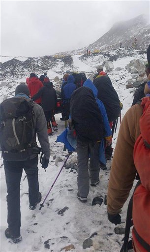 Climbers and guides carry an injured after an avalanche struck Everest Base Camp in Nepal, Saturday, April 25, 2015. An avalanche triggered by a massive earthquake in Nepal smashed into a base camp between the Khumbu Icefall, a notoriously treacherous rugged area of collapsed ice and snow, and the base camp where most climbing expeditions are, said Ang Tshering of the Nepal Mountaineering Association. (AP Photo/Pasang Dawa Sherpa)