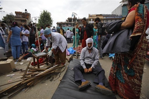 Injured people receive treatment outside Medicare Hospital in Kathmandu, Nepal, Saturday, April 25, 2015. A strong magnitude-7.9 earthquake shook Nepal's capital and the densely populated Kathmandu Valley before noon Saturday, causing extensive damage with toppled walls and collapsed buildings, officials said. (AP Photo/ Niranjan Shrestha)
