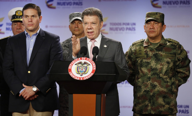 Colombias President Juan Manuel Santos announces that at least 26 leftist rebels have been killed in a raid in western Colombia, as he's flanked by Defense Minister Juan Carlos Pinzon, left, and Armed Forces Commander Gen. Juan Pablo Rodriguez, at the presidential palace in Bogota, Friday, May 22, 2015. Colombia's largest rebel group, the Revolutionary Armed Forces of Colombia (FARC), announced they're ending a unilateral cease-fire in response to the military raid on their guerrilla camp. (AP Photo/Fernando Vergara)