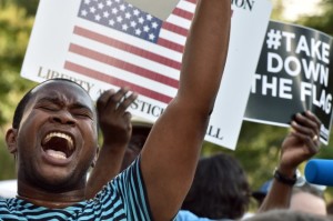 A man shouts slogans during a prprotest rally against the Confederate flag in Columbia, South Carolina on June 20, 2015. The racially divisive Confederate battle flag flew at full-mast despite others flying at half-staff in South Carolina after the killing of nine black people in an historic African-American church in Charleston on June 17. Dylann Roof, the 21-year-old white male suspected of carrying out the Emanuel African Episcopal Methodist Church bloodbath, was one of many southern Americans who identified with the 13-star saltire in red, white and blue. (AFP PHOTO/MLADEN ANTONOV)
