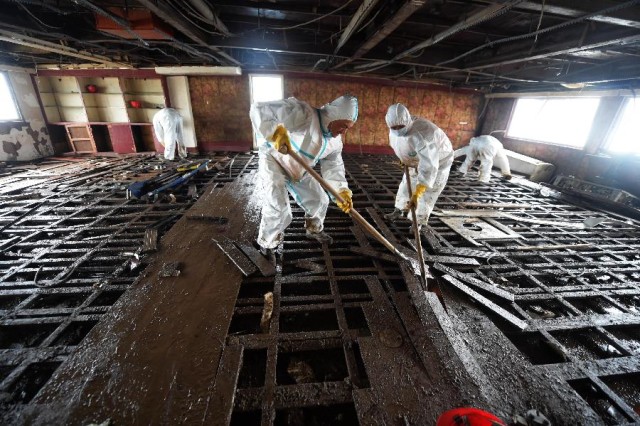 Rescuers remove the floorboard on the capsized ship Eastern Star in the Jianli section of the Yangtze River, central China's Hubei Province, June 8, 2015.