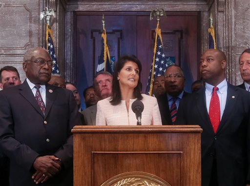 South Carolina Gov. Nikki Haley speaks during a news conference in the South Carolina State House, Monday, June 22, 2015, in Columbia, S.C. Haley said that the Confederate flag should come down from the grounds of the state capitol, reversing her position on the divisive symbol amid growing calls for it to be removed. Also pictured are U.S. Congressman James Clyburn, left, and U.S. Sen. Tim Scott, right. (Tim Dominick/The State via AP)