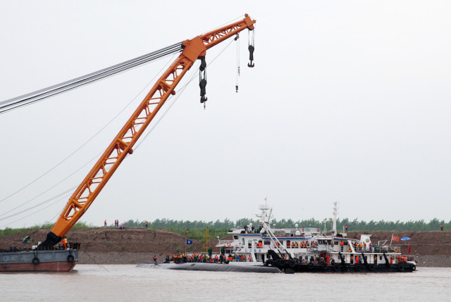 Rescuers contact search and rescue on the capsized ship, center, on the Yangtze River in central China's Hubei province Wednesday, June 3, 2015. (AP Photo/Andy Wong)