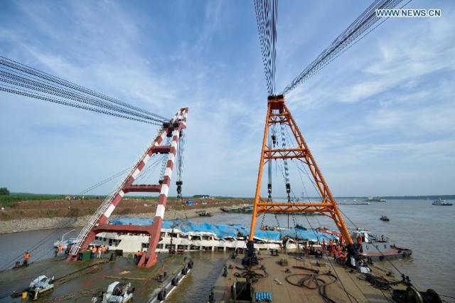 Photo taken on June 5, 2015 shows the capsized cruise ship Eastern Star being hoisted in the section of Jianli on the Yangtze River, central China's Hubei Province. The cruise ship that capsized in the Yangtze River on Monday night carrying 456 people is being hoisted from the river after rescuers righted it on Friday morning. (Xinhua/Bai Yu)