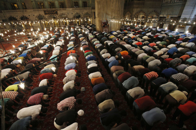 Muslims pray in the iconic Sultan Ahmed Mosque, better known as the Blue Mosque, in the historic Sultanahmet district of Istanbul, Turkey, late Wednesday, June 17, 2015, during the first 'taraweeh', nightly prayer of the month of Ramadan. (AP Photo/Emrah Gurel)