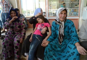 Family members of a wounded person from the Syrian town of Ayn al-Arab or Kobani wait outside a hospital in the border town of Suruc, Turkey, Thursday, June 25, 2015. Islamic State militants launched two major attacks in northern Syria on Thursday, storming government-held areas in the mostly Kurdish city of Hassakeh and pushing into Kobani  the Syrian Kurdish border town they were expelled from early this year  where they set off three cars bombs, killing and wounding dozens, activists and officials said.(AP Photo)
