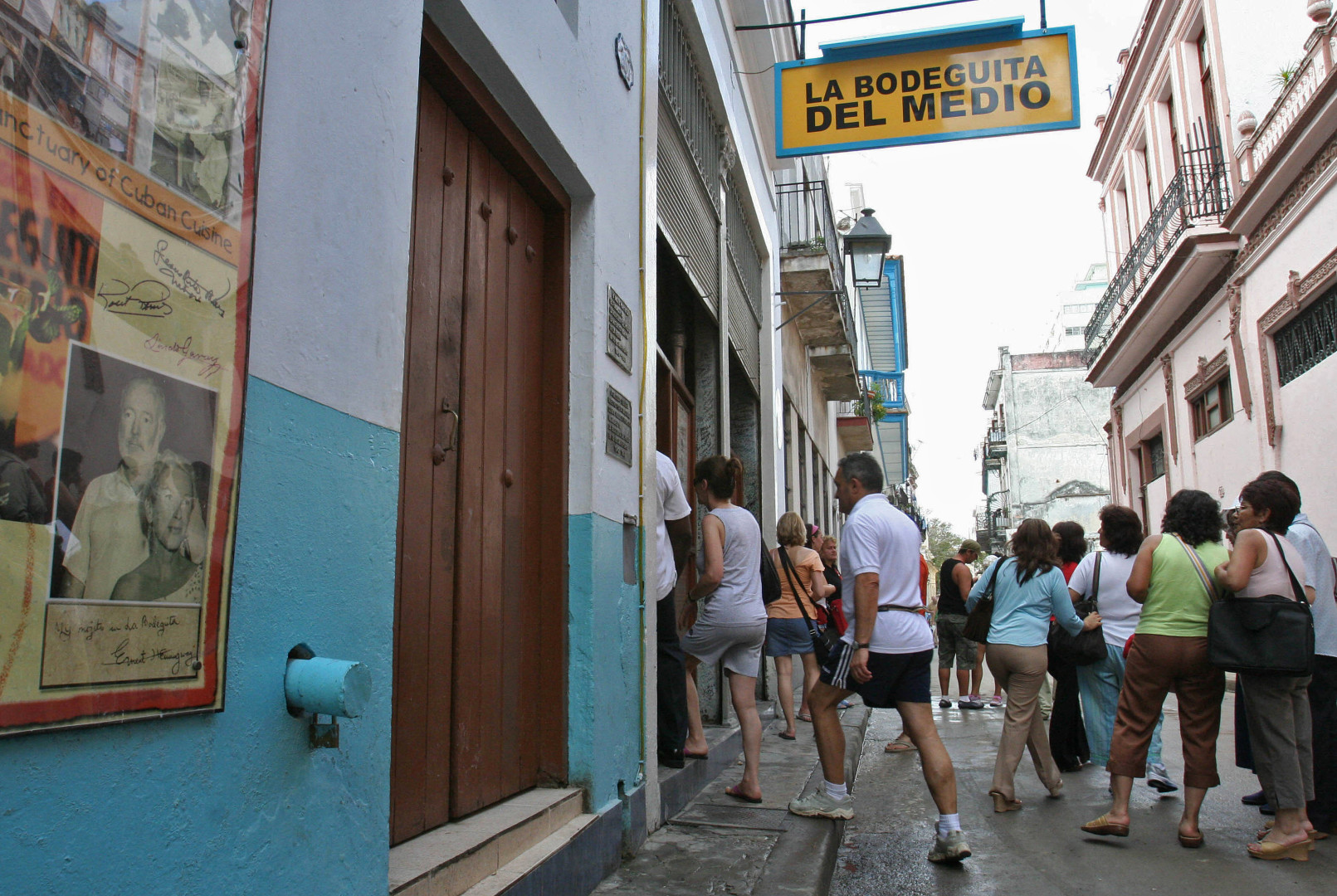 Tourists enter the Bodeguita del Medio -strongly linked to Ernest Hemingway's life in Cuba- on February 3, 2007, in Havana. (AFP PHOTO/Adalberto ROQUE)