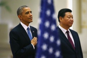 U.S. President Barack Obama (L) and China's President Xi Jinping listen to national anthems behind a U.S. flag during a welcoming ceremony at the Great Hall of the People in Beijing, November 12, 2014. REUTERS/Petar Kujundzic