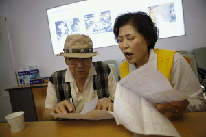 A South Korean man gets help to prepare a document at the Red Cross building in Seoul