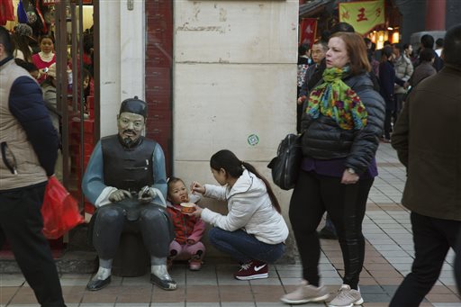A woman feeds a child in Beijing, China, Thursday, Oct. 29, 2015. (AP Photo/Ng Han Guan)