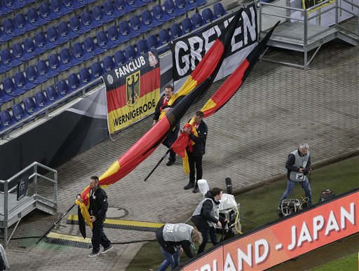 German flags are carried out of the stadium as the soccer friendly between Germany and the Netherlands was cancelled in Hannover, Germany, Tuesday, Nov. 17, 2015. (AP Photo/Michael Sohn)