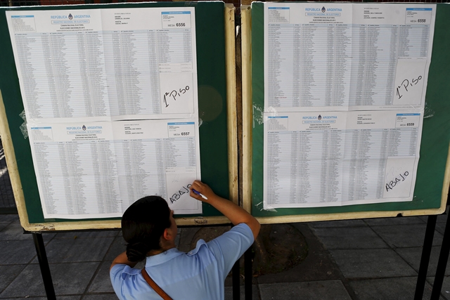 A police officer writes on a national voter registration list in a voting station during the presidential election at Buenos Aires, Argentina, November 22, 2015. Photo by Ivan Alvarado.