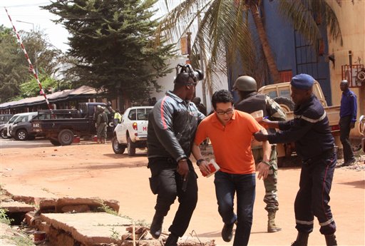 FILE -- In this Friday, Nov. 20, 2015 file photo, Mali troopers assist a hostage to leave the Radisson Blu hotel to safety after gunmen attacked the hotel, in Bamako, Mali. (AP Photo/Harouna Traore, File)