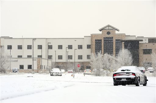 The scene surrounding the Planned Parenthood clinic, left, is quiet as law enforcement officers continue the investigation on Saturday, Nov. 28, 2015 following Friday's's shooting in Colorado Springs, Colo. The suspect, Robert Lewis Dear, surrendered to law enforcement and is now in police custody. (Daniel Owen/The Gazette via AP)