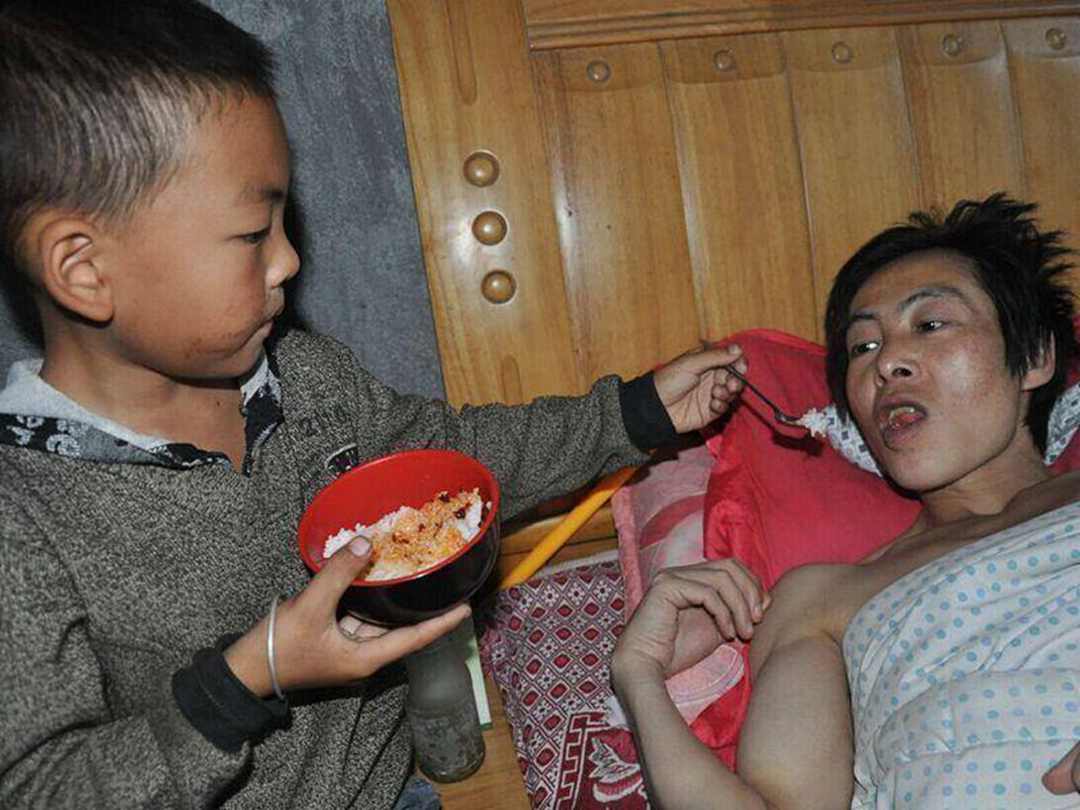 Seven-year-old schoolboy taking care of his paralyzed father