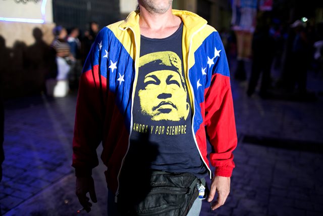 A pro-government supporter wears a T-Shirt with image of Venezuela's late President Hugo Chavez, as he waits for results during congressional elections in Caracas, Venezuela, Sunday, Dec. 6, 2015. (AP Photo/Alejandro Cegarra)