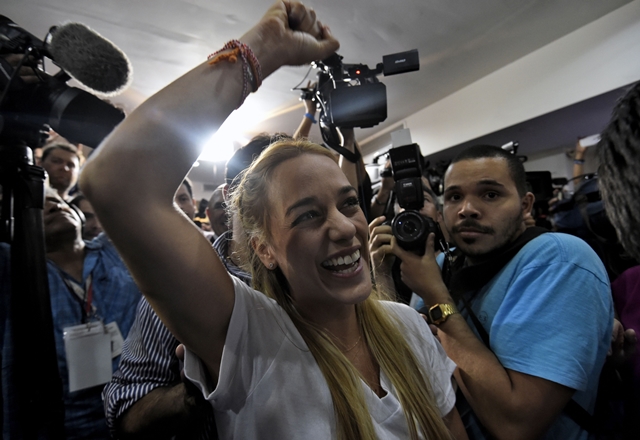 The wife of jailed Venezuelan opposition leader Leopoldo Lopez, Lilian Tintori celebrates after knowing the first results of the legislative election, at the MUD headquarters in Caracas, on the early morning December 7, 2015. Venezuela's opposition won --at least--a majority of 99 out of 167 seats in the state legislature, electoral authorities said Monday, the first such shift in power in congress in 16 years. AFP PHOTO/JUAN BARRETO