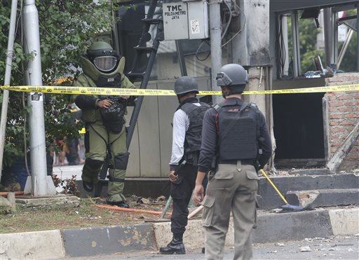 Members of the police bomb squad inspect a police post where an explosion went off in Jakarta, Indonesia Thursday, Jan. 14, 2016. Attackers set off explosions at a Starbucks cafe in a bustling shopping area in Indonesia's capital and waged gunbattles with police Thursday, leaving bodies in the streets as office workers watched in terror from high-rise buildings. (AP Photo/Tatan Syuflana)