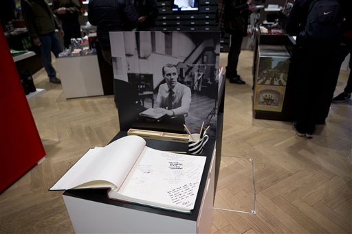 A book of condolence and an image of George Martin, the Beatles' producer, stand in memory of him in the Abbey Road shop by the studios where the Beatles recorded albums and where the zebra crossing cover picture of the Abbey Road album was originally taken, in London, Wednesday, March 9, 2016. George Martin, the Beatles' urbane producer who quietly guided the band's swift, historic transformation from rowdy club act to musical and cultural revolutionaries, has died, his management said Wednesday March 9, 2016. He was 90. (AP Photo/Matt Dunham)