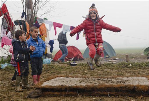 Migrant children play jumping on a muddy mattress at the northern Greek border point of Idomeni, Greece, Friday, March 18, 2016. Leaders of the EU's 28 divided nations plan to reconvene in Brussels this week in hopes of ironing out disagreements on a proposed agreement with Turkey in the migrants crisis.(AP Photo/Vadim Ghirda)