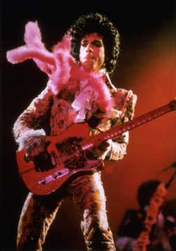 Prince playing guitar in concert