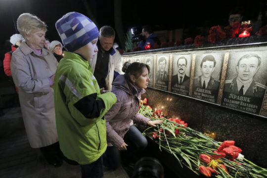 People lay flowers to commemorate victims of the Chernobyl nuclear disaster