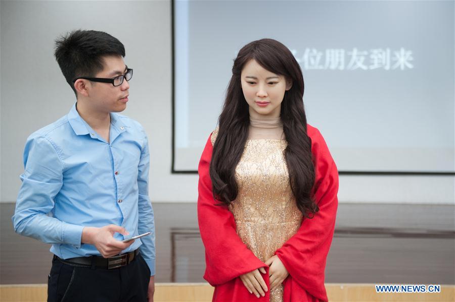 Robot "Jiajia" (R) interacts with a technician at the campus of the University of Science and Technology of China in Hefei, capital of east China's Anhui Province, April 15, 2016. (Xinhua/Meng Dingbo)
