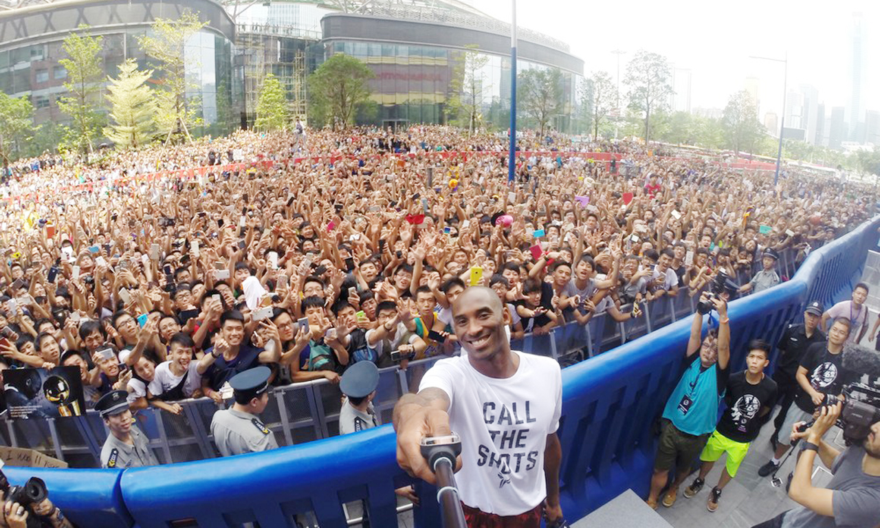 NBA basketball player Kobe Bryant of Los Angeles Lakers takes a selfie with fans during a promotional event at a store in Guangzhou, Guangdong province, China, August 2, 2015. Photo by CFP.