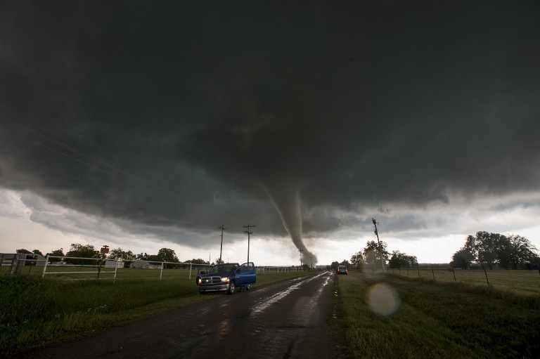 Vehicles stop on the side of a road as a tornado rips through a residential area after touching down south of Wynnewood, Oklahoma on May 09, 2016. (AFP / Josh Edelson)
